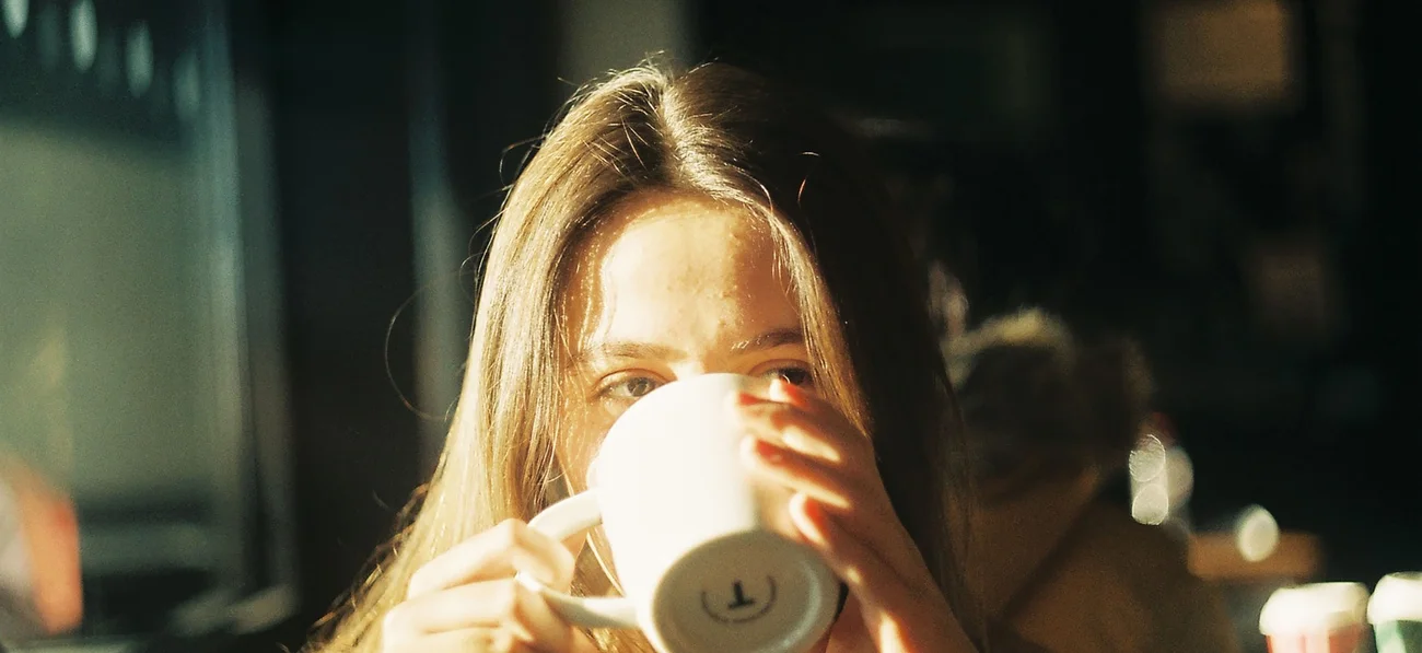 Person drinking coffee in warm light